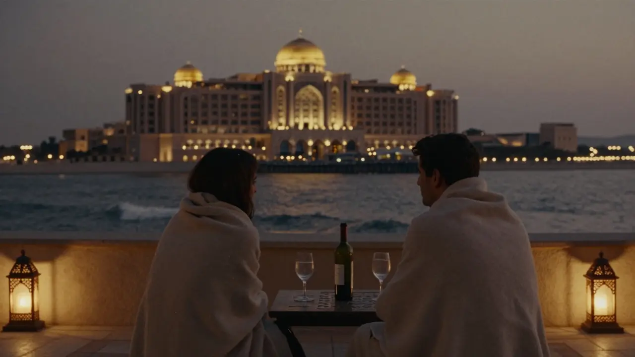 A quiet terrace behind Emirates Palace at night, two people under blankets with wine, golden domes glowing in the distance.